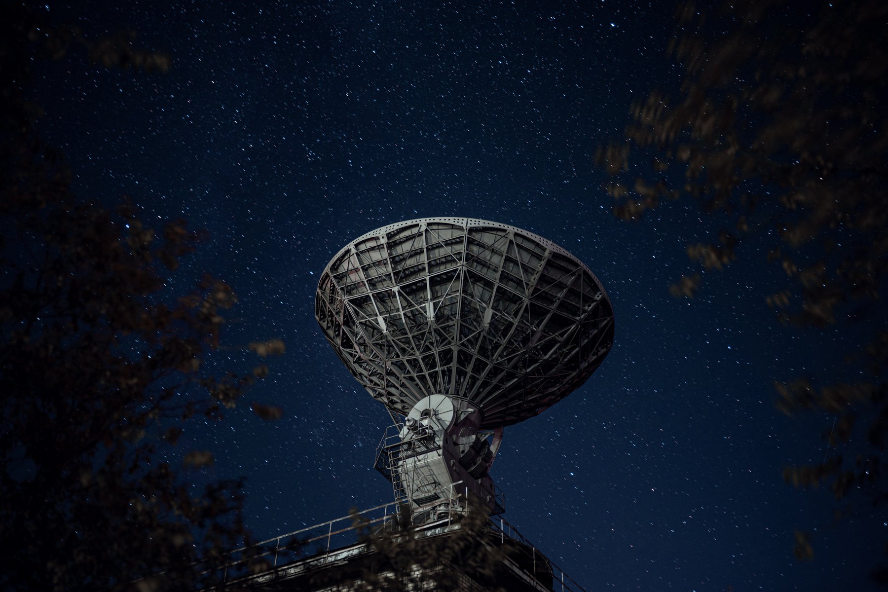 Radio telescope against sky with stars